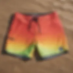 Vibrant board shorts laid out on a sandy beach