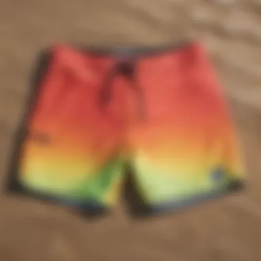 Vibrant board shorts laid out on a sandy beach