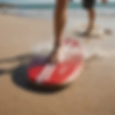 Close-up of specialized skimboarding gear on the sand.