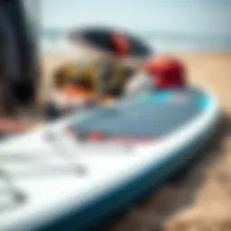An array of paddleboarding gear laid out on a sandy beach