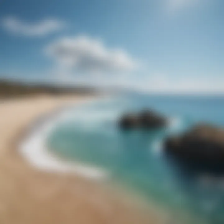 A breathtaking view of a serene beach meeting the vibrant sea under a clear blue sky