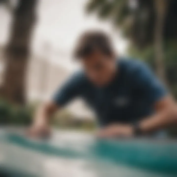 An individual applying epoxy to a surfboard